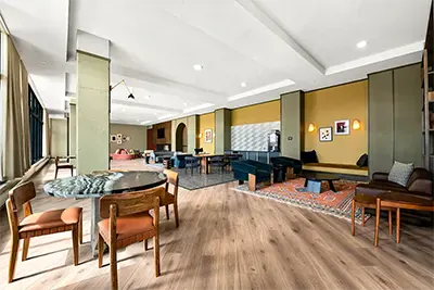 Vibrant resident game room featuring table tennis, arcade cabinets, and comfortable lounge seating