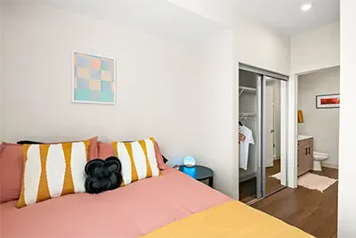 Reverse view of the student bedroom highlighting the large closet space and wood-style flooring